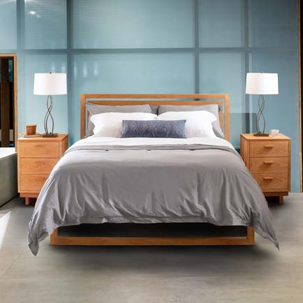A bedroom with a bed, dresser and nightstand.