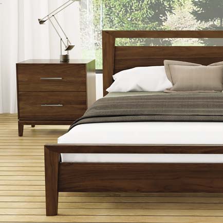 A bedroom with a wooden bed and dresser.