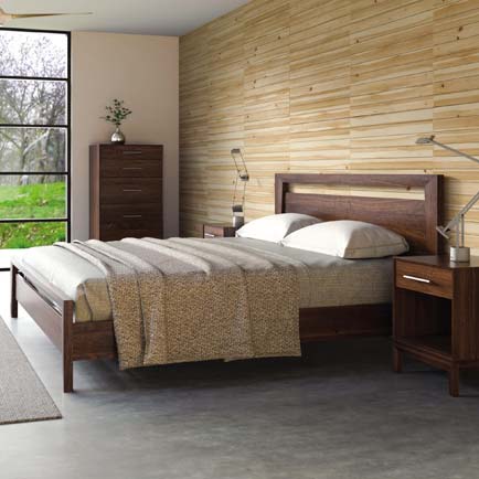 A bedroom with a bed, dresser and nightstand.