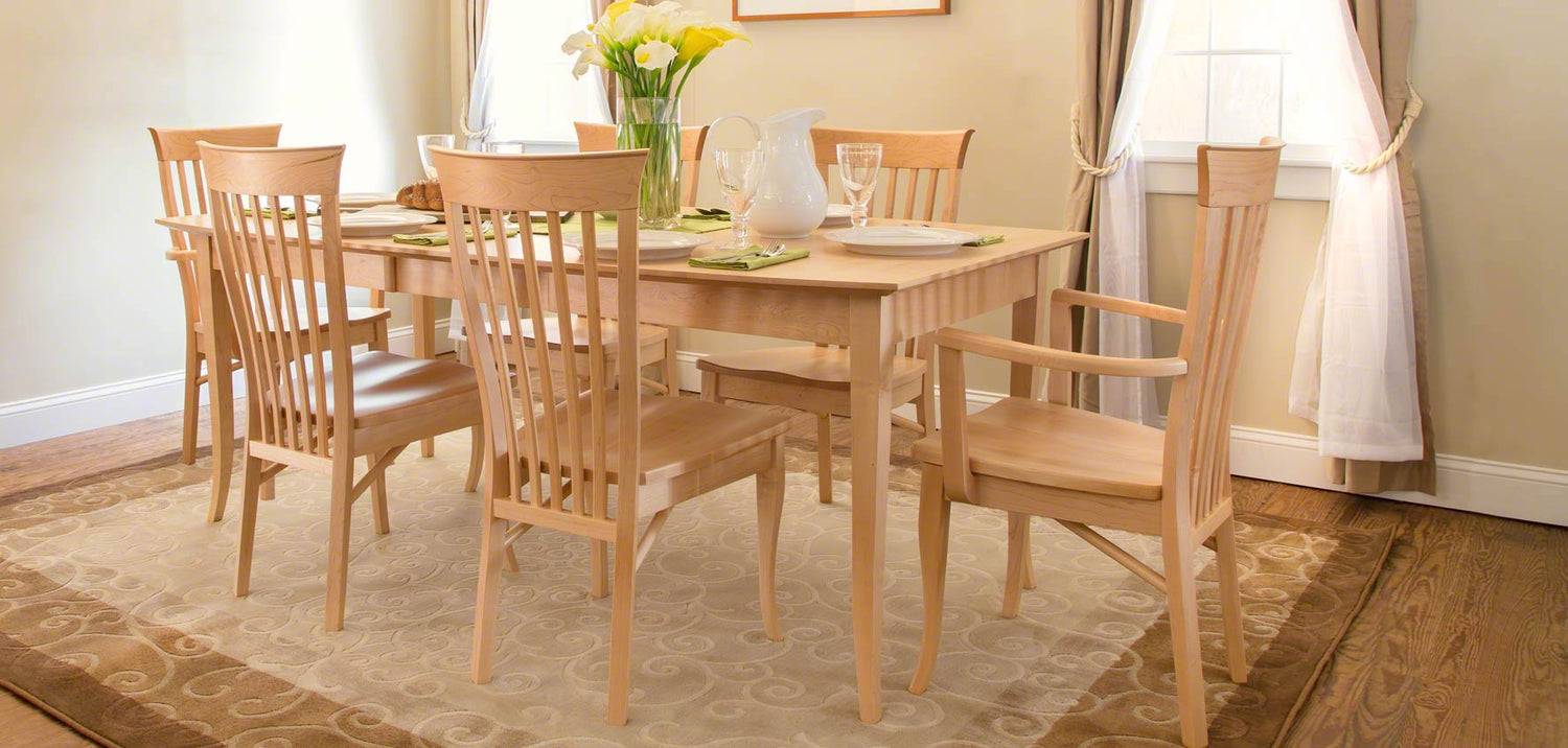 A dining room with a wooden table and chairs.