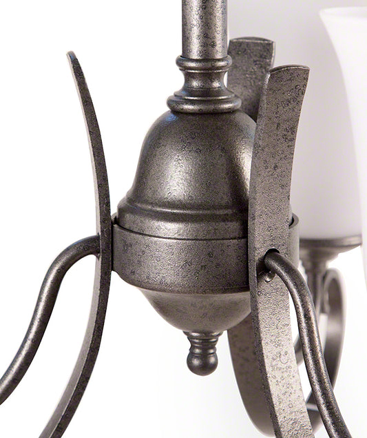 Detailed view of Hubbardton Forge Scroll Chandelier arm in natural iron with frosted glass shades, showcasing handcrafted American furniture design.