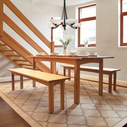 A dining room with a wooden table and chairs.
