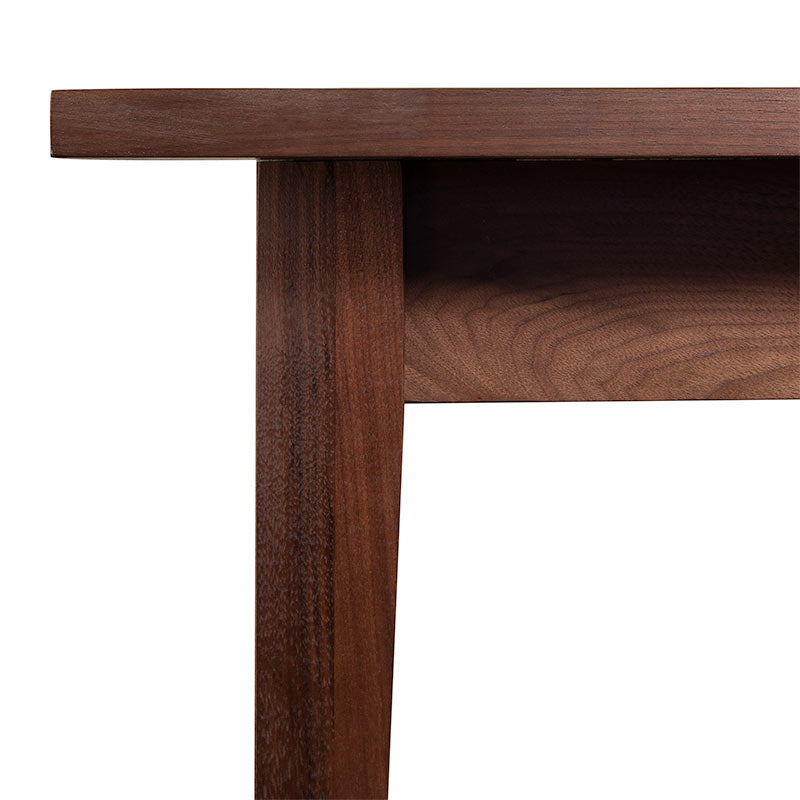 A close up image of a walnut dining table.