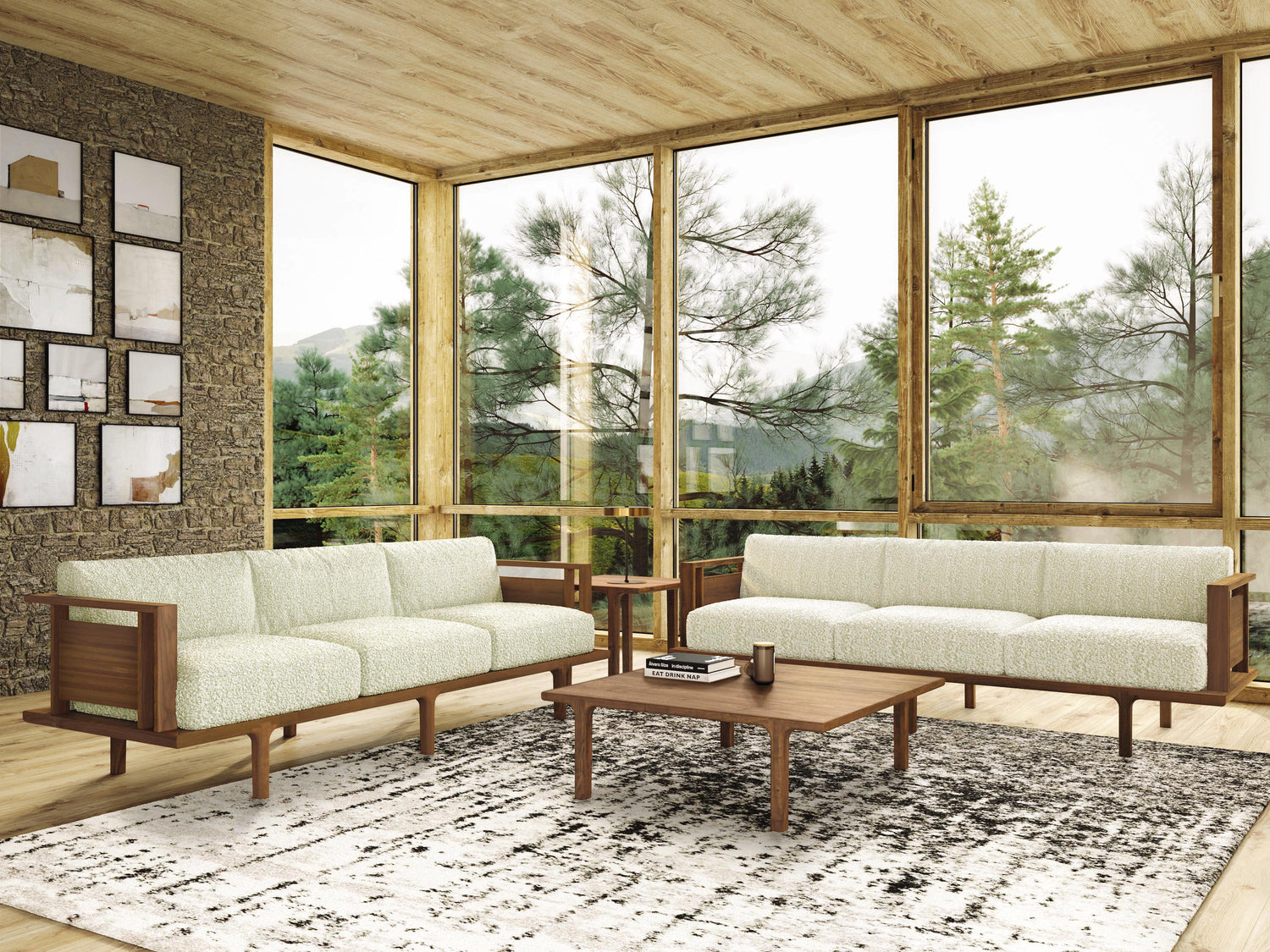 A spacious living room with large windows showcasing a forest view, modern furniture including a sofa set and a coffee table, and a patterned area rug on a wooden floor.