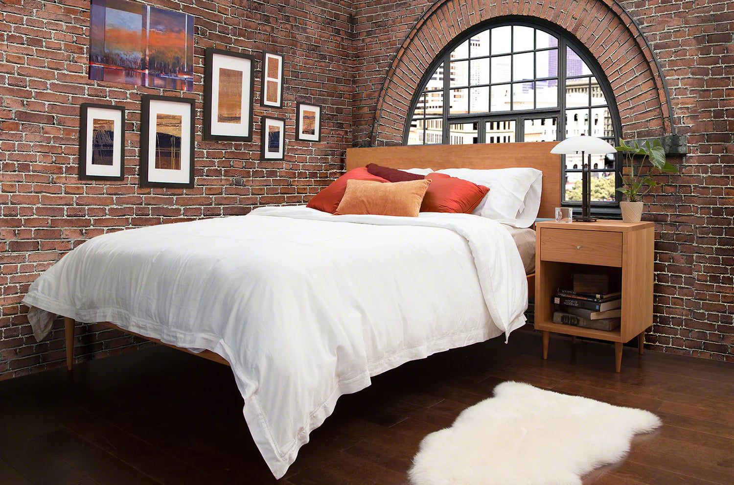 A bed in a room with a brick wall.
