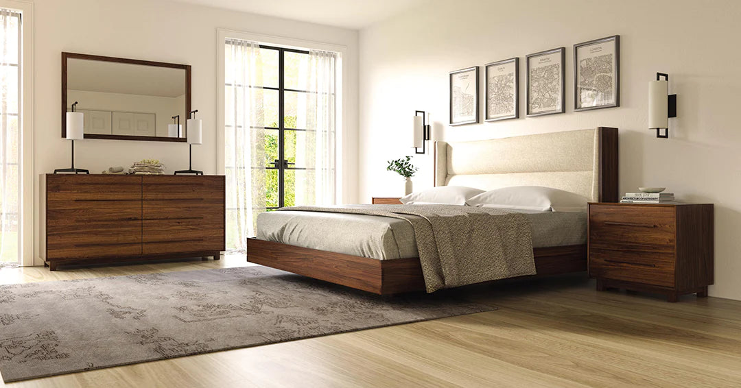A bedroom with a bed, dresser and mirror.