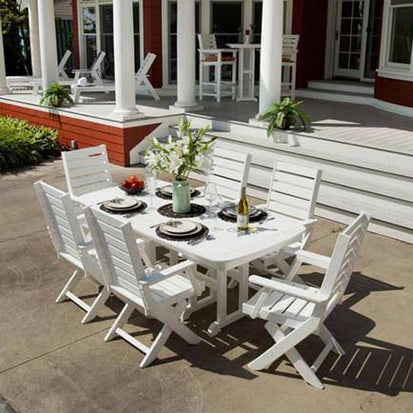 A white dining table and chairs on a porch.