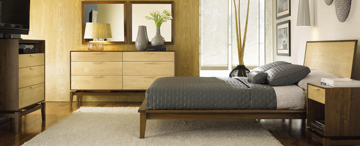 A bedroom with a bed, dresser and mirror.