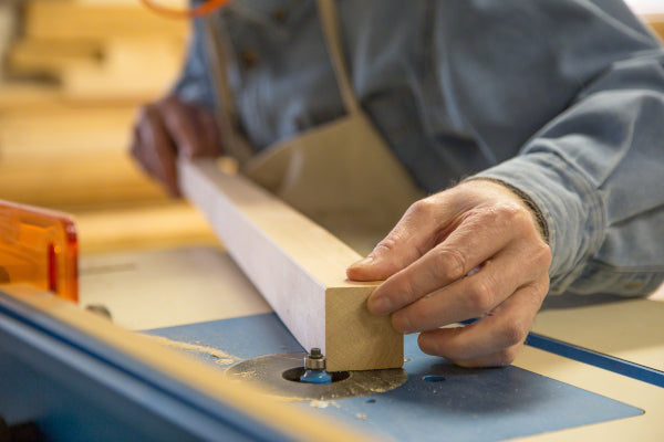 Crafting a wooden plank on a router table with precision.