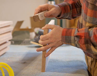 Handcrafted wooden furniture piece being sanded to a smooth finish.