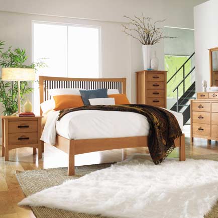 A bedroom with a bed, dresser and mirror.