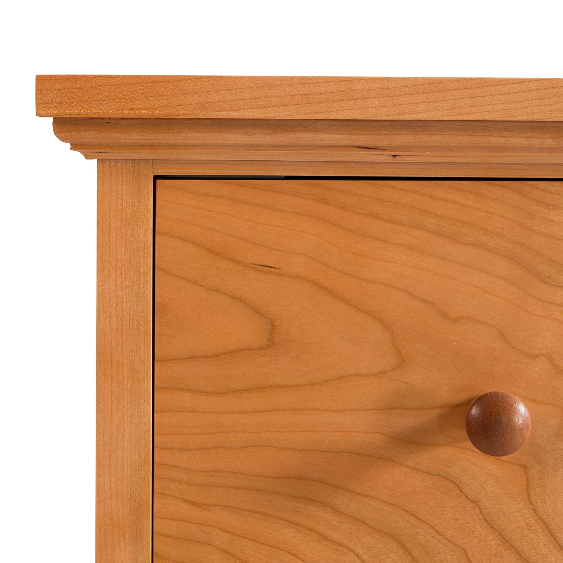 Close-up of a Lyndon Furniture American Country 6-Drawer Dresser corner featuring a smooth, rounded handle and a detailed wood grain pattern, set against a plain white background.
