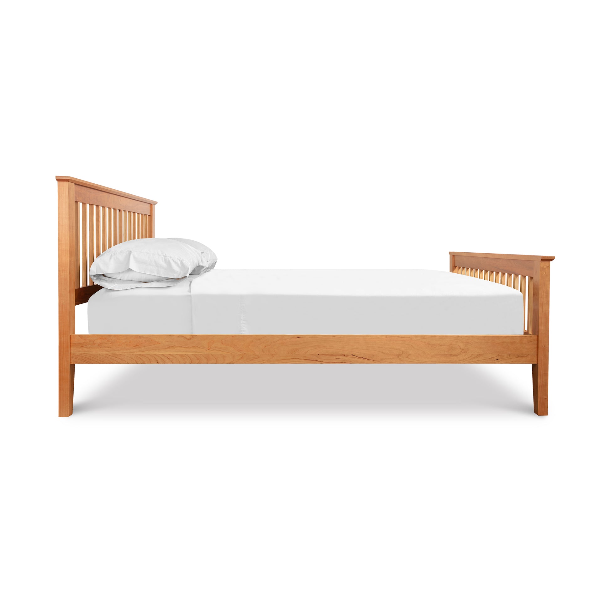 A high-quality, Lyndon Furniture American Mission Bed with a mission-style design and white sheets on it.