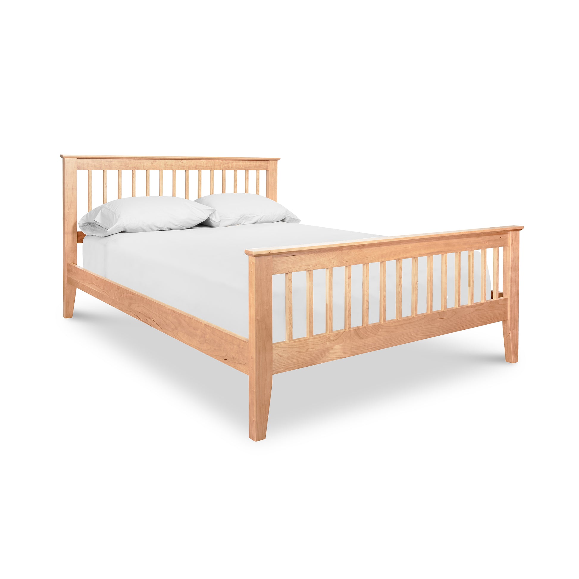 A high-quality wooden Lyndon Furniture American Mission bed adorned with white sheets.