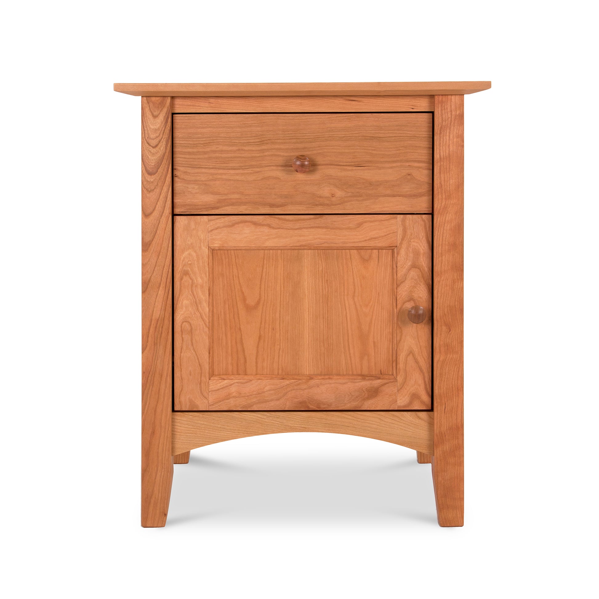 The Maple Corner Woodworks American Shaker 1-Drawer Nightstand with Door is a finely crafted piece of Vermont craftsmanship. Made from natural cherry wood, this small nightstand features a single drawer for convenient storage.