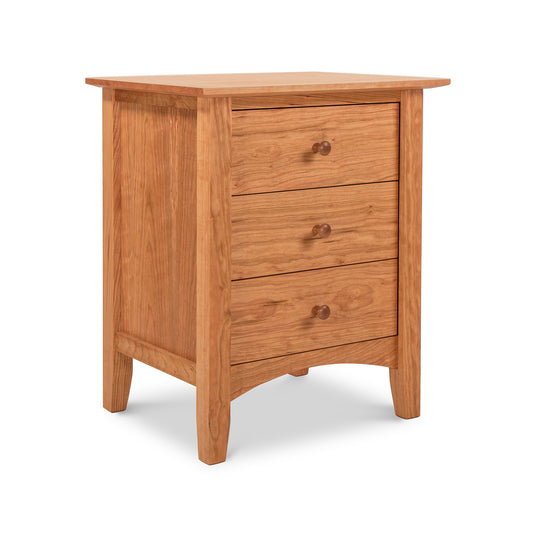 A Maple Corner Woodworks American Shaker 3-Drawer Nightstand crafted from eco-friendly materials, with three drawers, featuring round knobs and slightly slanted legs, isolated against a white background.