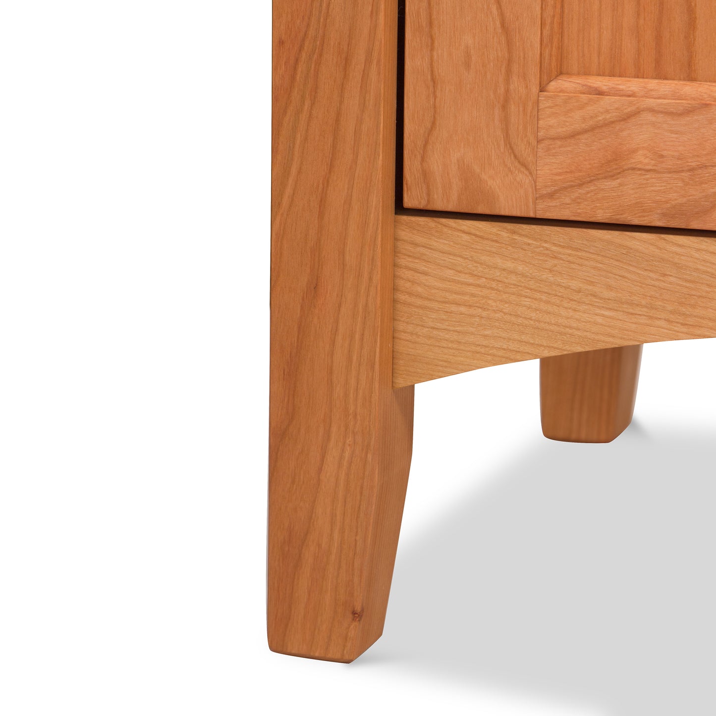 A close up of a handmade Maple Corner Woodworks American Shaker 3-Drawer Nightstand, showcasing exquisite Vermont craftsmanship.