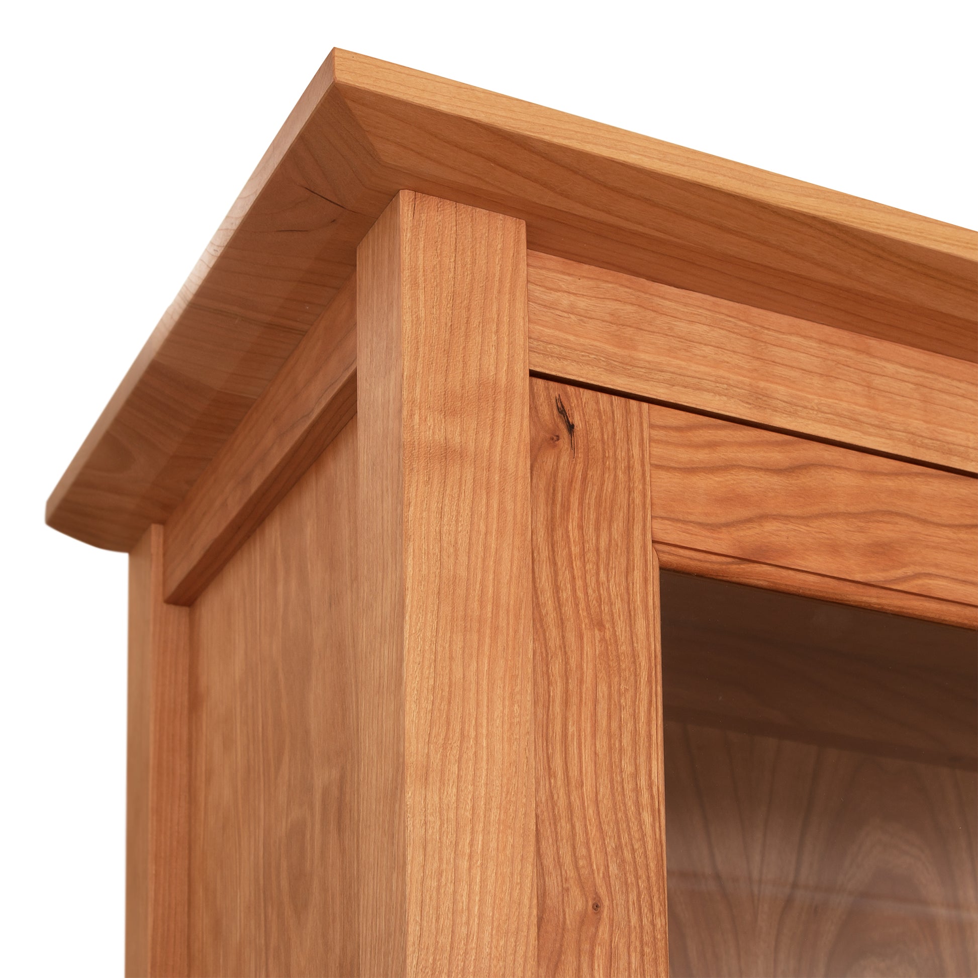 A close-up of a Maple Corner Woodworks American Shaker 50" China Cabinet corner showing the grain pattern and joinery.