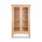 American Shaker Bookcase by Maple Corner Woodworks with glass double doors, five shelves, and round wooden handles, handcrafted in solid wood.