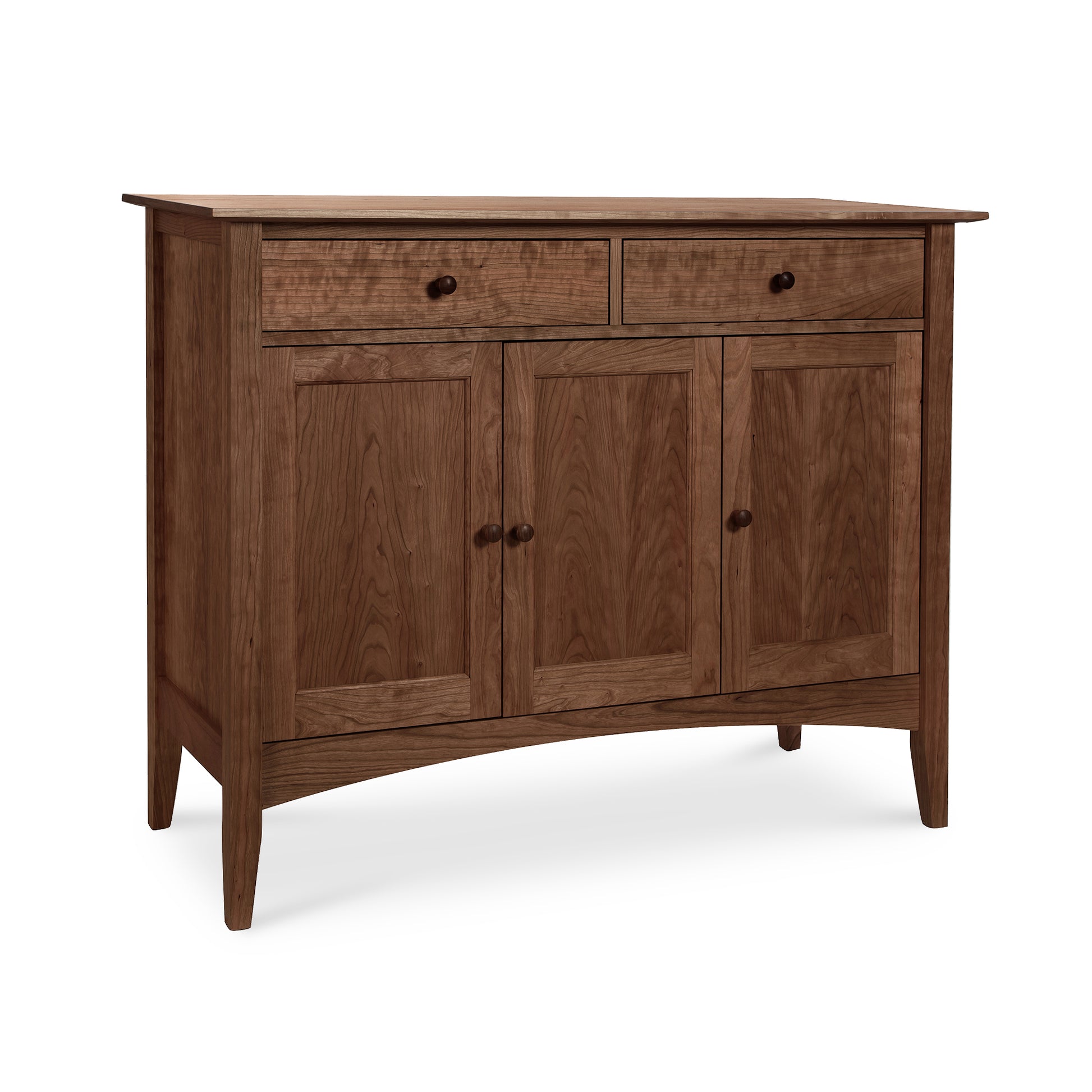 The American Shaker Medium Sideboard by Maple Corner Woodworks is crafted from solid hardwood with a natural finish. It features Vermont craftsmanship, two upper drawers, and three lower cabinet doors. Supported by four tapered legs, it embodies a simple and traditional American Shaker design.