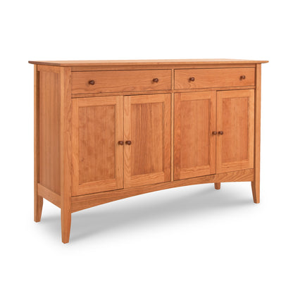 The American Shaker Large Sideboard by Maple Corner Woodworks is crafted from solid hardwood and features two drawers and four cabinet doors in a simple, classic design. It boasts a light, natural wood finish, highlighted by round knobs that emphasize its traditional American Shaker Furniture style.