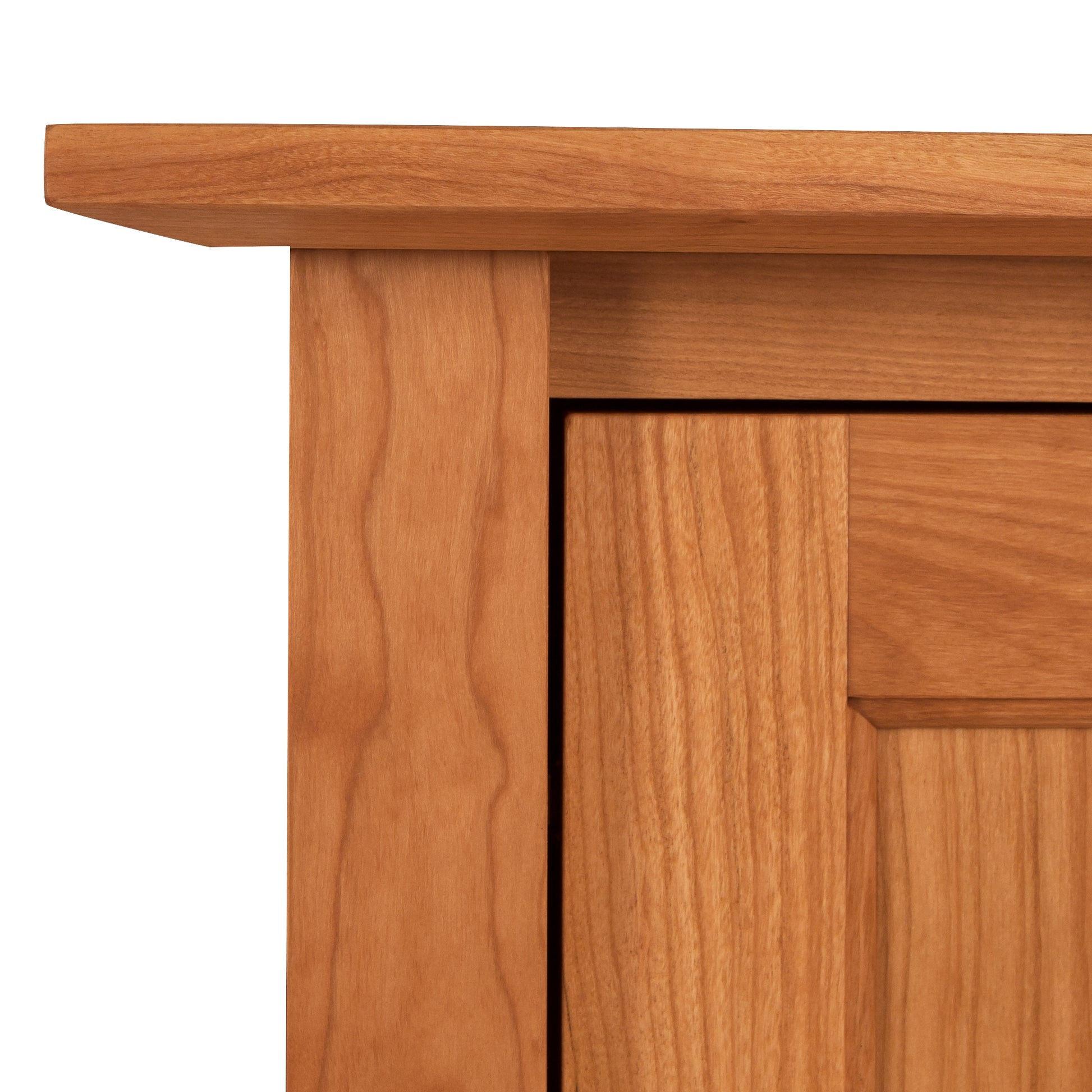 Close-up of an American Shaker 67" TV Stand by Maple Corner Woodworks, highlighting the grain pattern and construction details of the wood panels and edges.