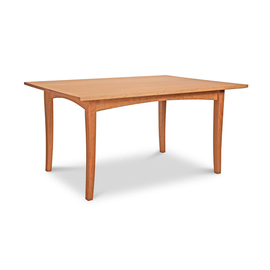 The American Shaker Rectangular Solid Top Table by Maple Corner Woodworks features a robust rectangular top and four subtly curved legs. This handcrafted table boasts a natural wood finish that beautifully showcases the exquisite hardwood, with its shadow cast on the white background emphasizing its sturdy elegance.