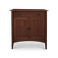 The American Shaker Small Sideboard by Maple Corner Woodworks is crafted from solid hardwood in Vermont and showcases a dark brown finish. Drawing inspiration from the American Shaker style, this piece features simple lines with a single drawer on top and two doors below, elegantly adorned with round knobs and supported by four tapered legs.