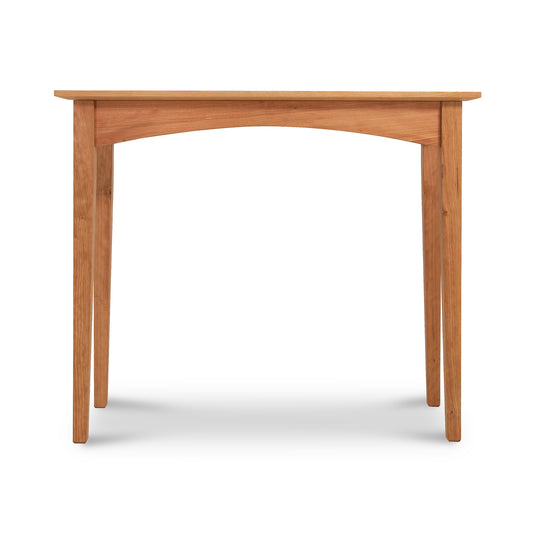 A simple American Shaker Sofa Table from Maple Corner Woodworks with a smooth tabletop and four splayed legs, isolated on a white background. The wood has a natural, light brown finish.