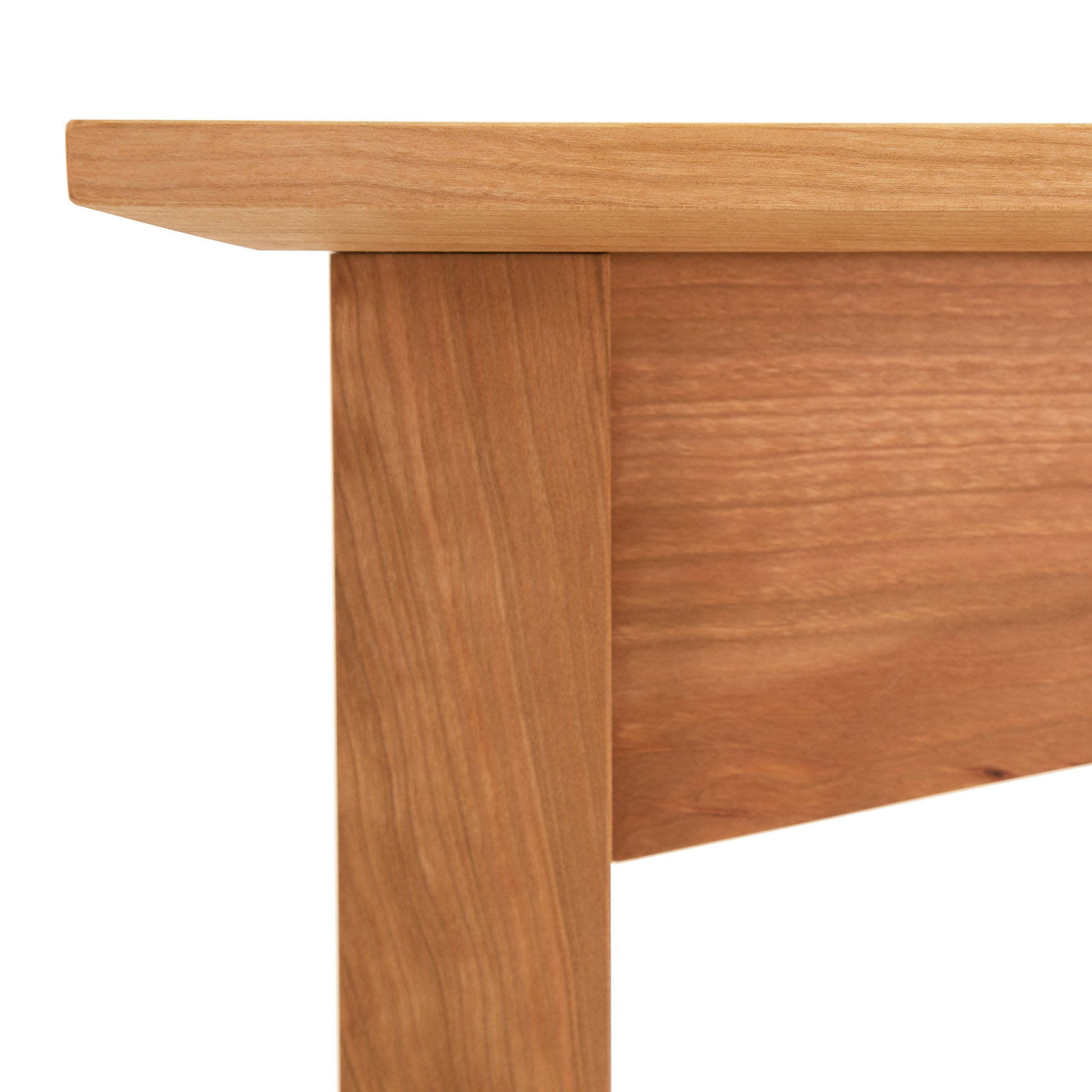 Detail of an eco-friendly American Shaker Sofa Table corner from Maple Corner Woodworks showing the tabletop and leg with a smooth finish and grain texture.