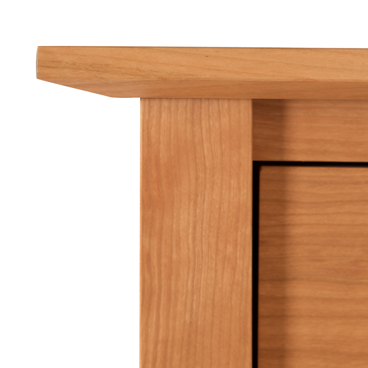 Detailed close-up of the smooth light brown wood grain on the top left corner of Maple Corner Woodworks American Shaker 7-Drawer Dresser.