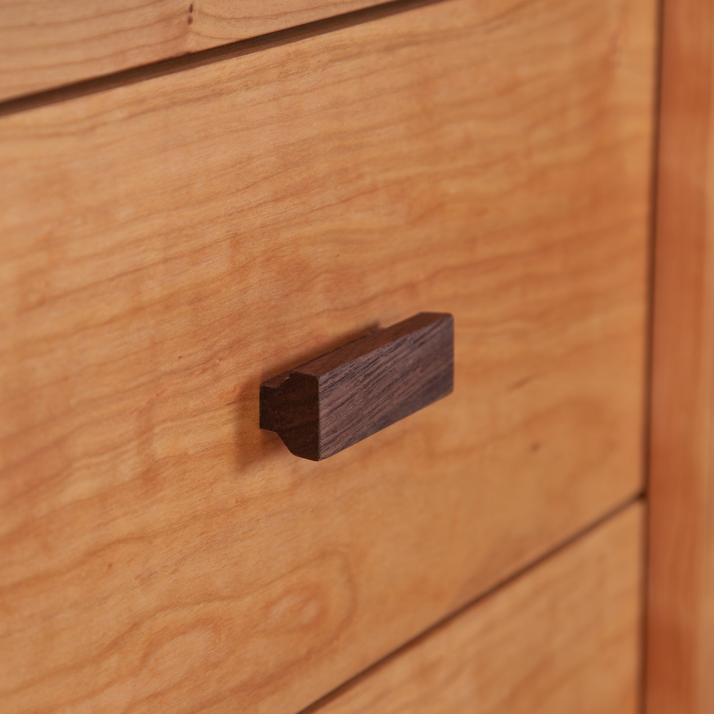 A close up of a Maple Corner Woodworks Andover Modern 3-Drawer Nightstand wooden drawer handle.