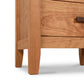 Close-up of an eco-friendly wooden Andover Modern 3-Drawer Nightstand by Maple Corner Woodworks, featuring a drawer with a black handle, showcasing the detailed grain and smooth finish of the wood against a white background.