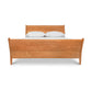 The Maple Corner Woodworks Andover Modern Incline Sleigh Bed features contemporary lines and a 10% inclined headboard and footboard. It is made of wood and is adorned with white sheets.