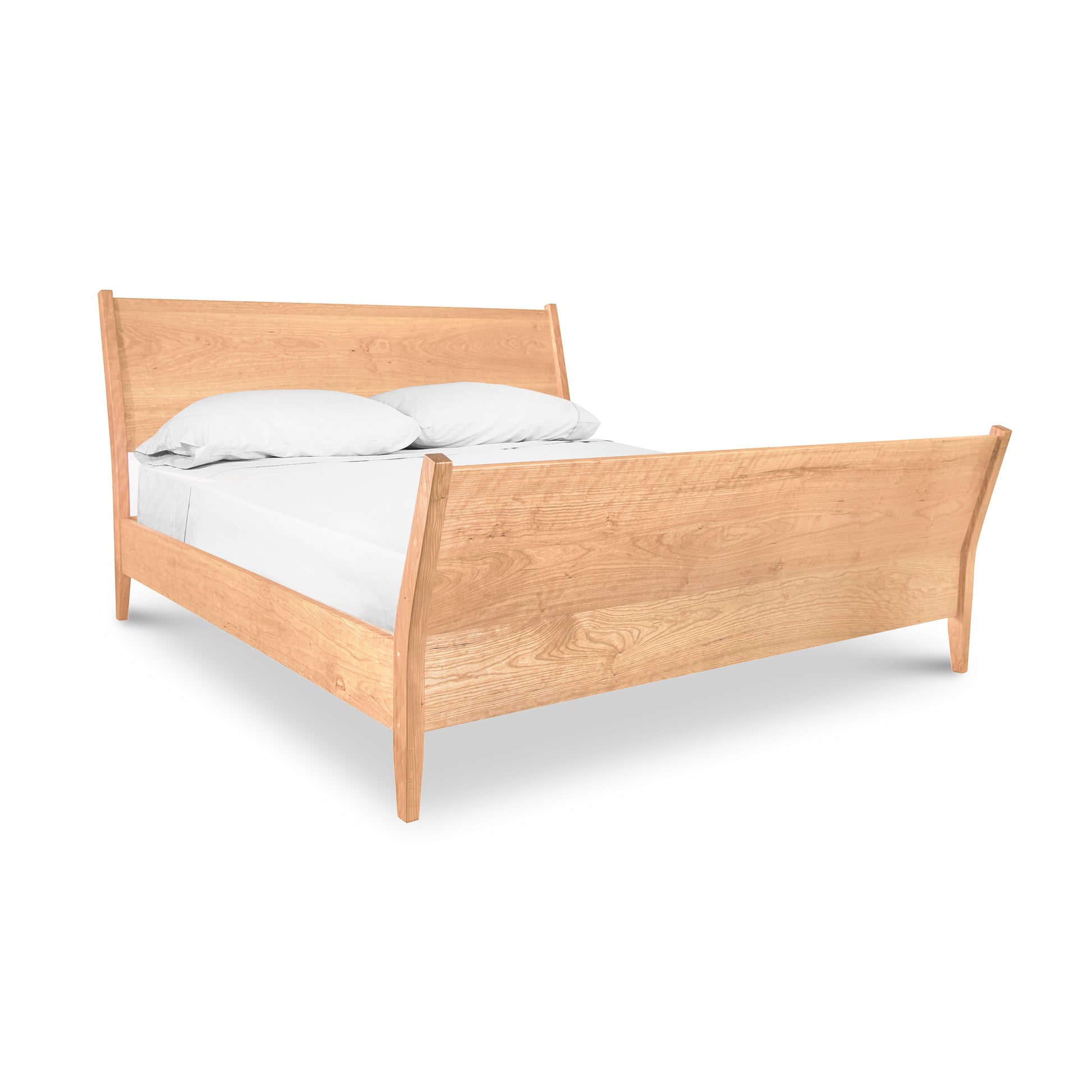 The Maple Corner Woodworks Andover Modern Incline Sleigh Bed features contemporary lines and is accompanied by white sheets, creating a stylish and ergonomic wooden bed.