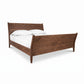 The Andover Modern Incline Sleigh Bed by Maple Corner Woodworks showcases a natural walnut wood frame with angled headboard and footboard, highlighting its sophisticated modern design.