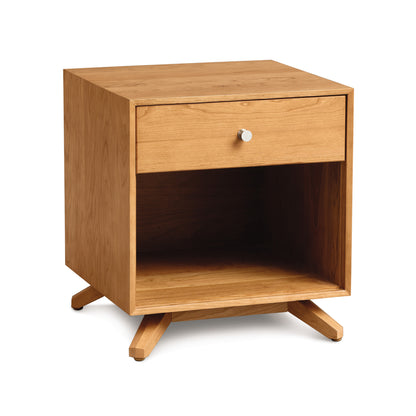 A modern American design Astrid 1-Drawer Enclosed Shelf Nightstand crafted from sustainable hardwood by Copeland Furniture, featuring one drawer and an open shelf on angled legs, isolated on a white background.