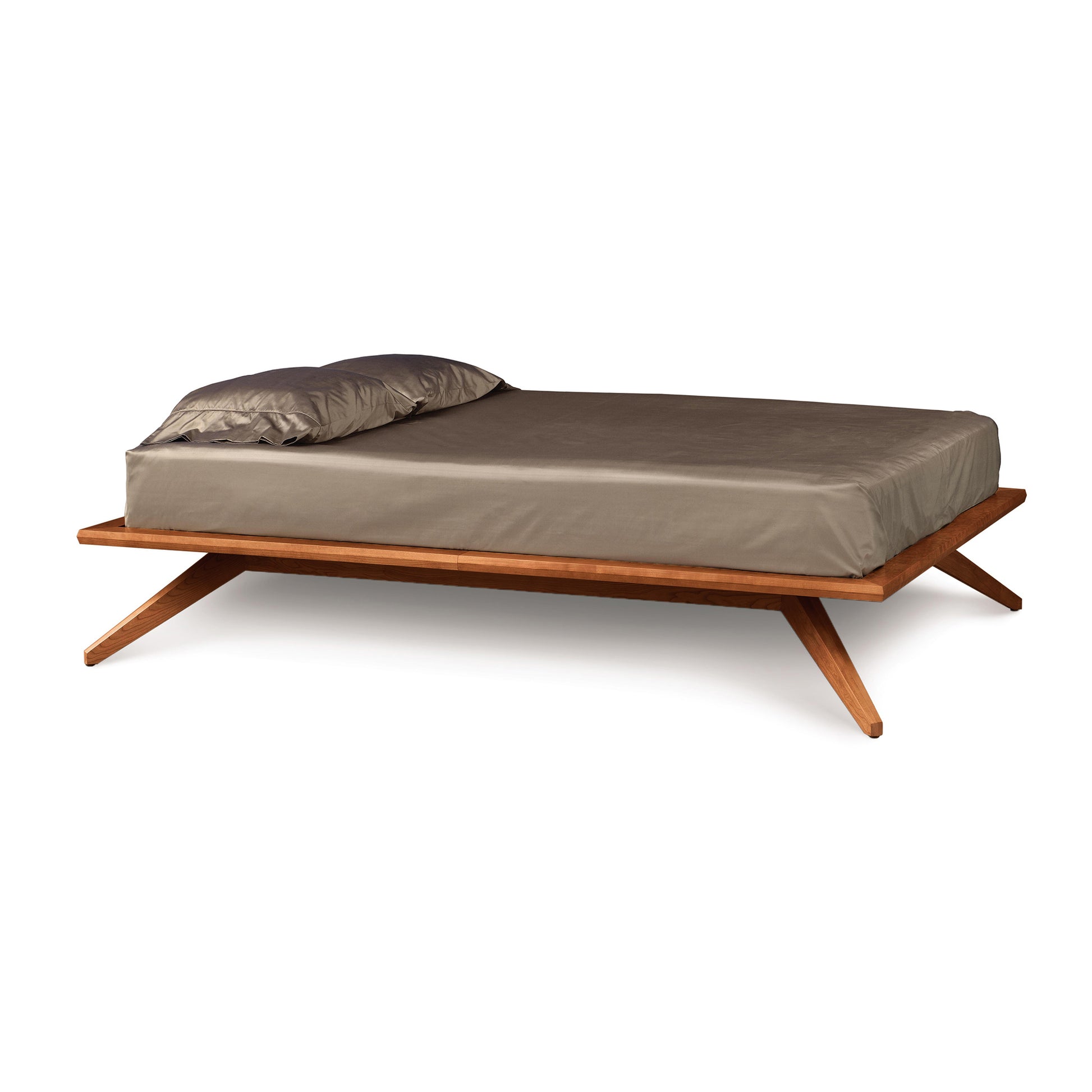 Astrid Platform Bed by Copeland Furniture, featuring mid-century design with angled legs and eco-friendly hardwood, accompanied by a matching brown mattress and pillow.