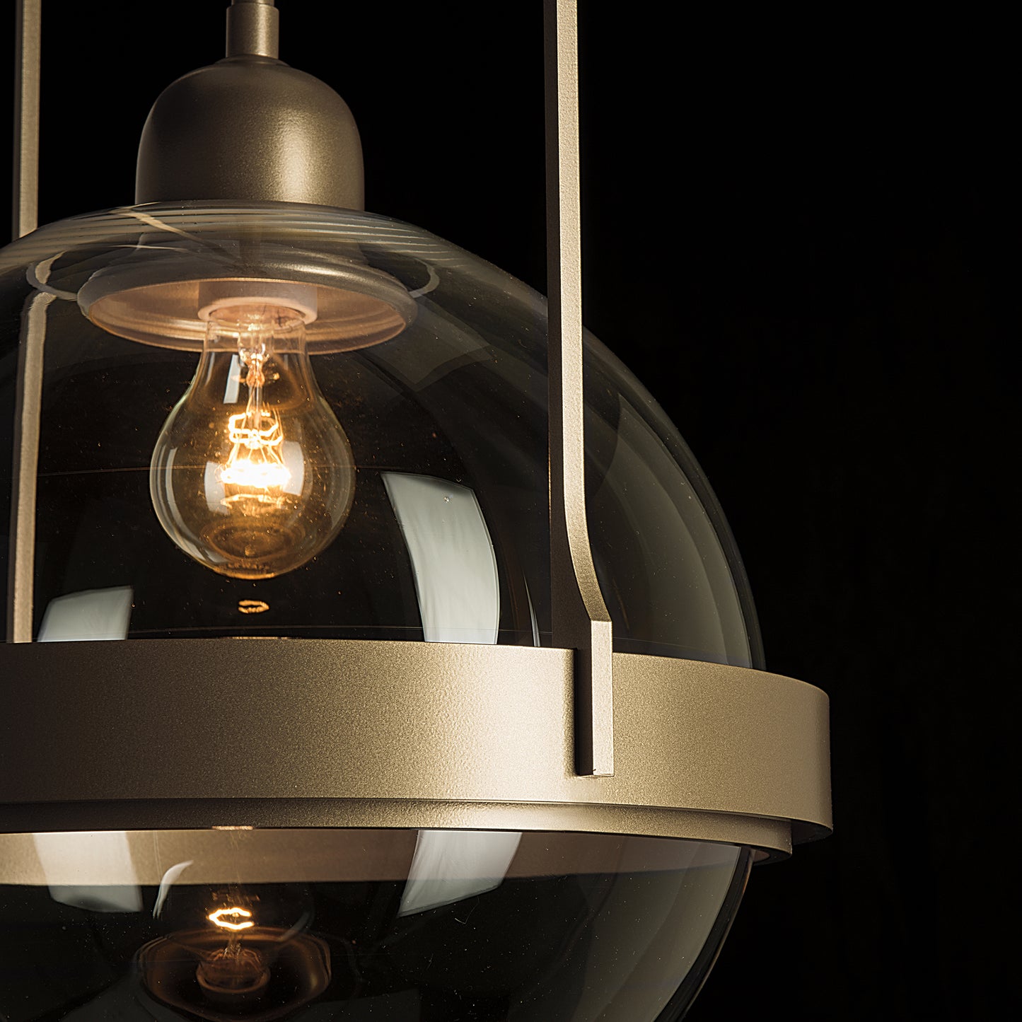 The Hubbardton Forge Atlas Mini Pendant, handcrafted in Vermont, is a stunning piece of Hubbardton Forge lighting featuring a light bulb hanging from a glass globe.