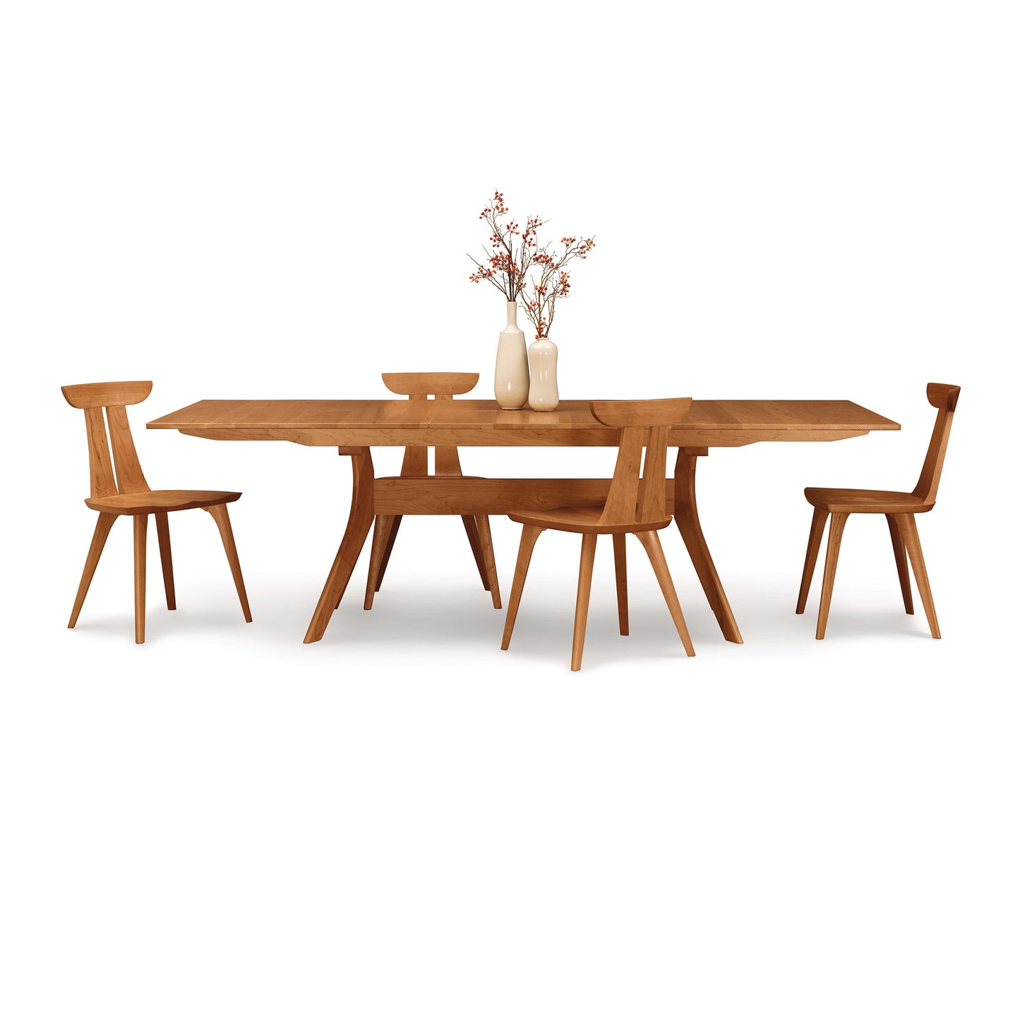 A dining table with four chairs and a vase.