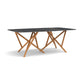Baton Sintered Stone Boat Top Table by Copeland Furniture with a black marble top and intersecting wood legs, showcasing American-made modern design.
