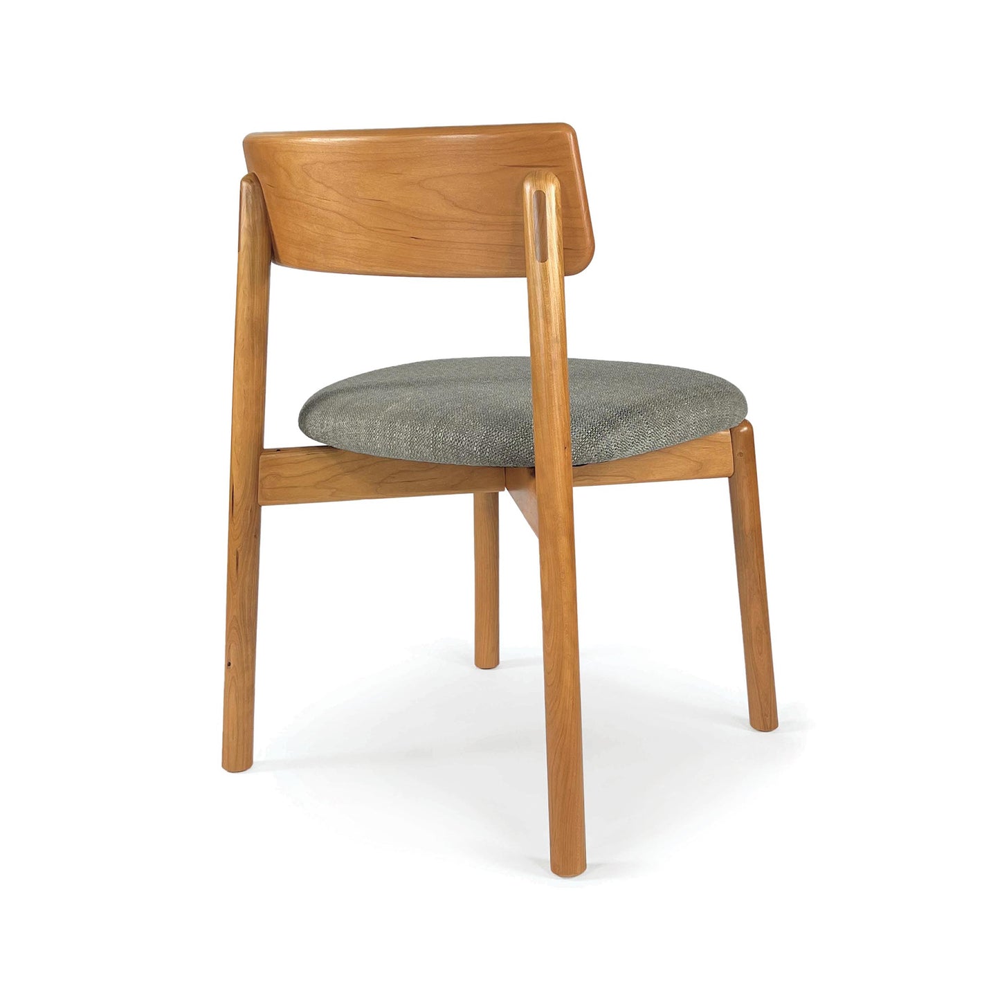 Baton Chair by Copeland Furniture shown in three-quarter rear view, highlighting its grey upholstered seat and angled backrest.