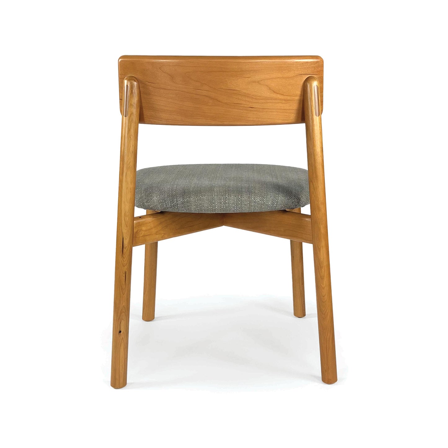 Baton Chair by Copeland Furniture with a curved wooden backrest and round gray upholstered seat, highlighted from the back for design detail.
