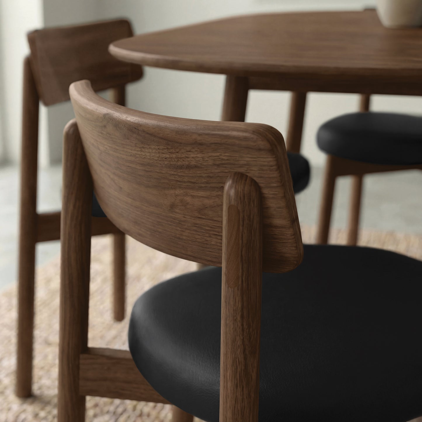 Copeland Furniture Baton Chairs with black cushions arranged around a solid wood dining table, highlighting premium American craftsmanship.
