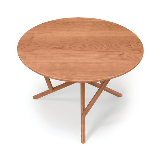 Copeland Furniture Baton Round Solid Top Dining Table with three crossed legs and a smooth wood surface, expertly crafted in solid wood.