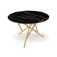 Baton Round Sintered Stone Top Table by Copeland Furniture with a black marble top and light wood crisscross legs, crafted in Vermont.