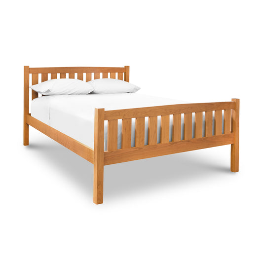 A Bennington Bed with High Footboard by Vermont Furniture Designs, with white sheets on a platform bed.