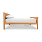 A solid cherry wood Vermont Furniture Designs Bennington Bed with High Footboard - Queen - Floor Model with white sheets on it.
