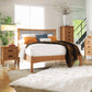 Copeland Furniture Berkeley Cherry Platform Bed with white/orange bedding, accompanied by a matching nightstand and dresser.