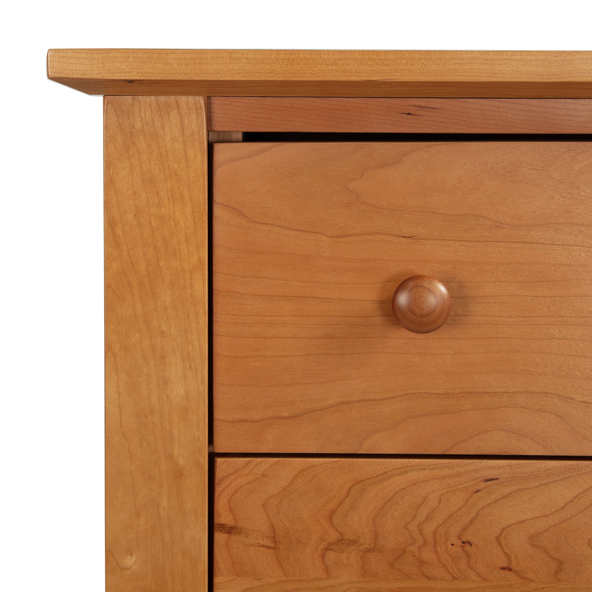 Close-up of the Lyndon Furniture Bow Front 6-Drawer Dresser corner, showcasing light solid wood construction and smooth grain. Features round wooden knobs, simple natural design, handmade in Vermont using premium materials like maple and cherry wood. Perfect example of American-made furniture with a clean and elegant finish.